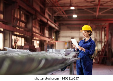 Side view portrait of female worker holding digital tablet while supervising production at factory, copy space - Powered by Shutterstock