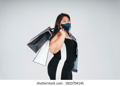 Side View - Portrait Of Healthy Asian Chubby Woman Wearing Mask And Holding Shopping Bags On White Background.