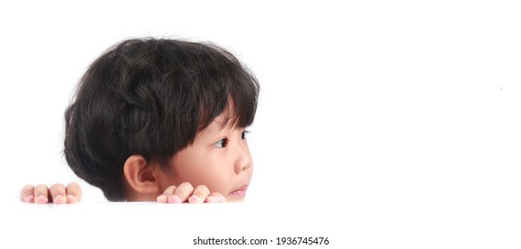 Side View Portrait Of A Little Asian Boy Looking To His Left Against White Background. Copy Space.