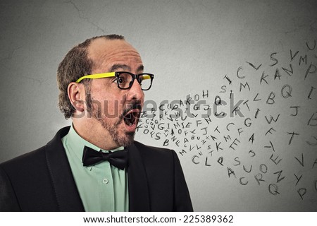 Side view portrait middle aged business man talking with alphabet letters coming out of open mouth isolated grey wall background. Human face expression emotion perception. Communication concept