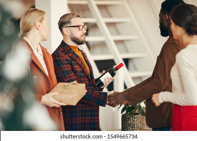 Side View Portrait Of Modern Couple Welcoming Guests To Elegant Dinner Prty At Home, Copy Space