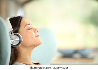 Side View Portrait Of A Relaxed Woman Listening To Hifi Music Sitting At Home