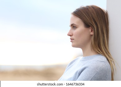 Side View Portrait Of A Serious Pensive Woman Looking Away On The Beach