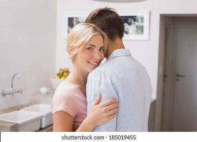 Side view portrait of a smiling young couple embracing at home - Shutterstock ID 185019455