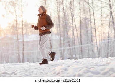 Side View Portrait Of Sporty Mature Woman Running In Winter Forest And Smiling, Copy Space