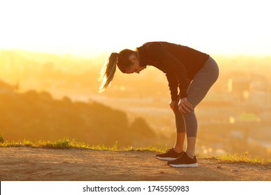 Side view portrait of a tired runner resting after exercise in city outskirts at sunset - Powered by Shutterstock