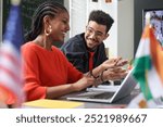 Side view portrait of two students man and woman laughing happily while enjoying work together in multicultural school classroom