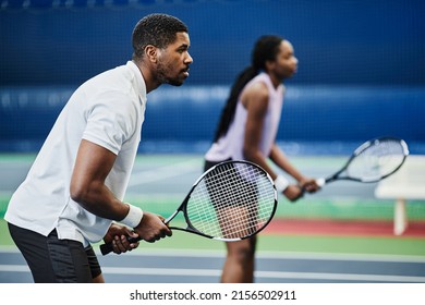 Side view portrait of two young African American people playing tennis at indoor court, copy space - Powered by Shutterstock