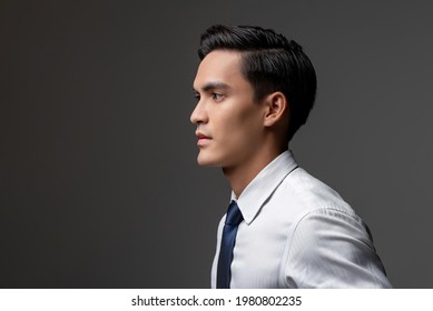 Side View Portrait Of Young Handsome Asian Man In Corporate Wear On Gray Isolated Studio Background