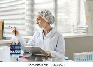 Side View Portrait Of Young Medical Technician Holding Test Tubes With Blood Samples In Laboratory, Copy Space