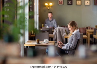 Side view of pregnant woman using digital tablet at cafe - Powered by Shutterstock