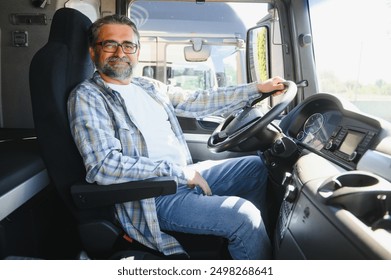 Side view of professional driver behind the wheel in truck's cabin.