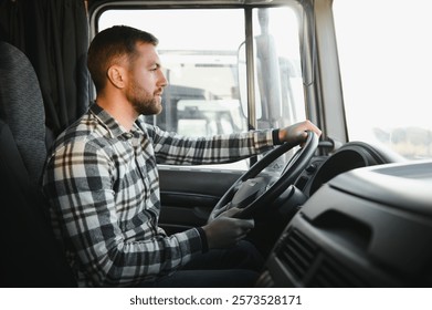 Side view of professional driver behind the wheel in truck's cabin.