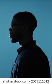 Side view profile outline of African-American male silhouette against deep blue background - Shutterstock ID 2063111012