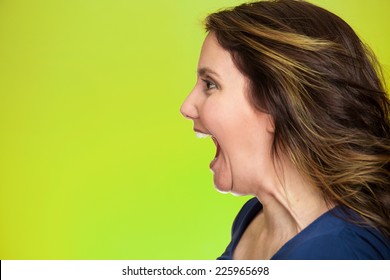 Side View Profile Portrait Beautiful Angry Woman Screaming Wide Open Mouth Isolated On Green Background. Negative Human Emotions, Face Expression, Feelings, Anger Management Problems 