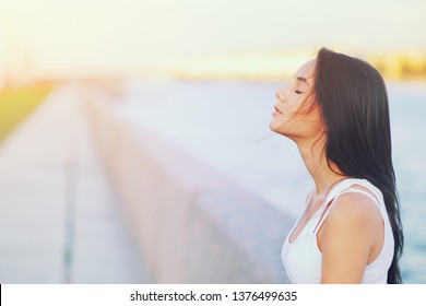 Side view profile portrait of a happy brunette woman relaxing breathing fresh air outdoors in summer Girl closed eyes doing deep breath exercises. Positive emotion success, peace of mind, zen concept.