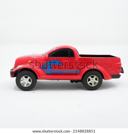 side view of a red pickup truck toy isolated in a white background