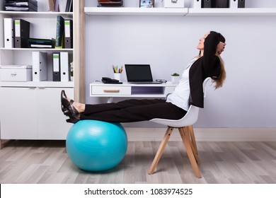 Side View Of A Relaxed Businesswoman Stretching Her Arms - Powered by Shutterstock