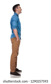 Side View Of Relaxed Casual Man Looking Up At Something While Standing On White Background