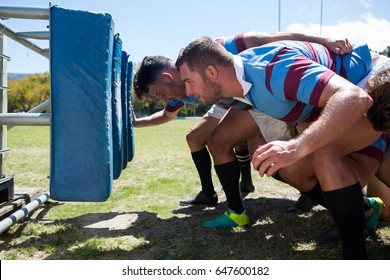 Side view of rugby players crouching at field on sunny day - Powered by Shutterstock