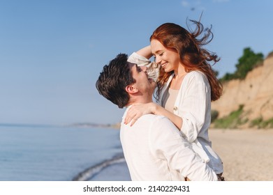 Side view satisfied young couple two friends family man woman in white clothes boyfriend hug hold girlfriend at sunrise over sea sand beach ocean outdoor exotic seaside in summer day sunset evening