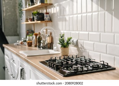 Side view of scandinavian style kitchen interior in white tones with stove, sink and shelves. Luxury apartment for sale. Cozy place for cooking concept - Shutterstock ID 2080928002
