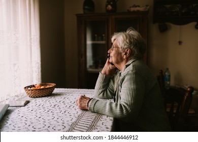 Side View Of Senior Caucasian Female Talking On The Phone With Her Family During Quarantine COVID - 19 Coronavirus