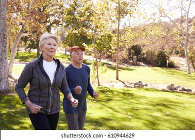 Side View Of Senior Couple Power Walking Through Park