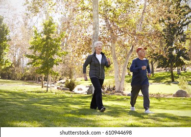 Side View Of Senior Couple Power Walking Through Park