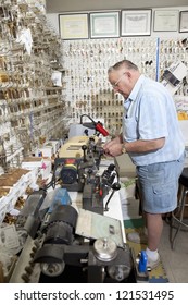 Side View Of Senior Locksmith Working In Store