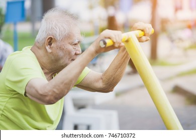 side view of seniors doing exercise Arms and legs with using cycling exercise bikes on park. elderly man or people retired relaxing in park. retired,health and lifestyle concept