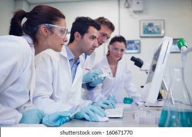 Side view of serious researchers looking at computer screen in the laboratory