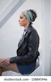 Side View Of Serious Woman With Hairband Sitting On Stairs