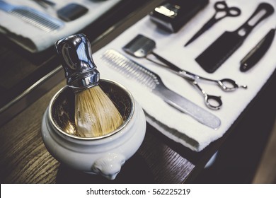 Side view of a shaving kit and a brush lying on a tray with a white towel. Concept of beauty and haircare.