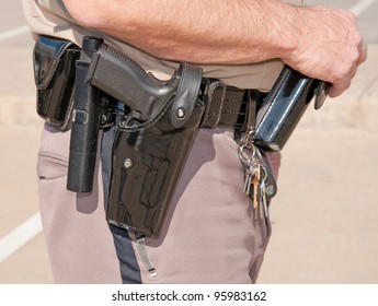 Side View Of A Sheriff's Deputy's Black Patent Leather Duty Belt With Holsters And Clips