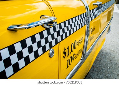 Side View Of A Shining Yellow Becker Taxi With Black And White Grid Displaying Ride Fare, New York, USA 