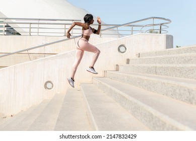 Side View Shot Of An African Woman Running Up Stairs. Woman Runner Climbing Stairs- Fitness, Sport Concept