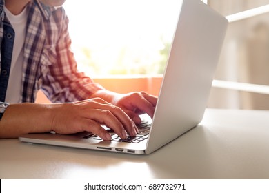 Side view shot of a man's hands typing on laptop keyboard for business or education, Online shopping concept.