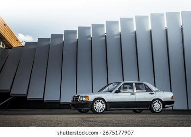 Side view slightly from the front of a German two tone zilver and black classic car with long antenna at a beautiful photo location