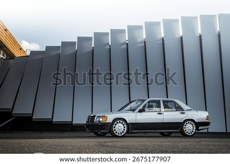 Side view slightly from the front of a German two tone zilver and black classic car with long antenna at a beautiful photo location