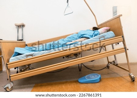 side view of sloped homecare electric hospital bed with patient at home