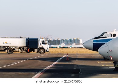 Side View Small Modern Fuel Tanker Truck Driving On Airfield Taxiway For Aircraft Refueling. Cistern Lorry Aviation Gasoline. Plane Gas Supply. Airport Maintenance Handling Service Vehicle Equipment