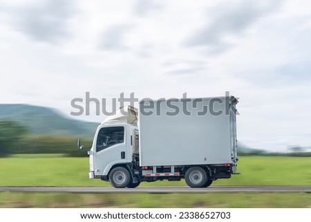 Side view of a small truck driving on a country road, truck running on the road, small truck on the road.
