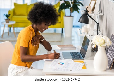 side view of smiling african american female freelancer working at home - Shutterstock ID 1082417942