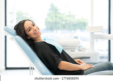 Side view of smiling Caucasian mid adult woman resting on chair at odontology center - Powered by Shutterstock