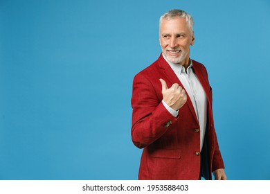 Side view of smiling elderly gray-haired mustache bearded business man wearing red jacket suit standing pointing thumb aside on mock up copy space isolated on blue color background studio portrait - Powered by Shutterstock