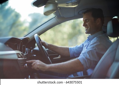 Side View Of Smiling Man Driving Car