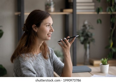 Side View Smiling Woman Recording Audio Message On Smartphone, Chatting In Social Network, Positive Attractive Young Woman Using Phone, Making Call, Talking On Loudspeaker, Activating Voice Assistant