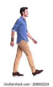 Side View Of A Smiling Young Casual Man Walking , On White Background