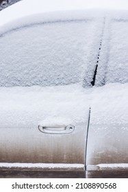 Side View Of Snow Covered Car After Snowfall. Many New White Snow On A Dirty Car. Part Of A Car. Doors, Handle And Windows